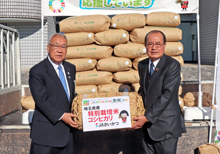 木津・三郷市長（左）に米俵のレプリカを手渡すＪＡさいかつの根岸組合長