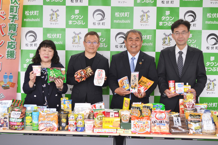 寄付された食品を手にする関係者たち