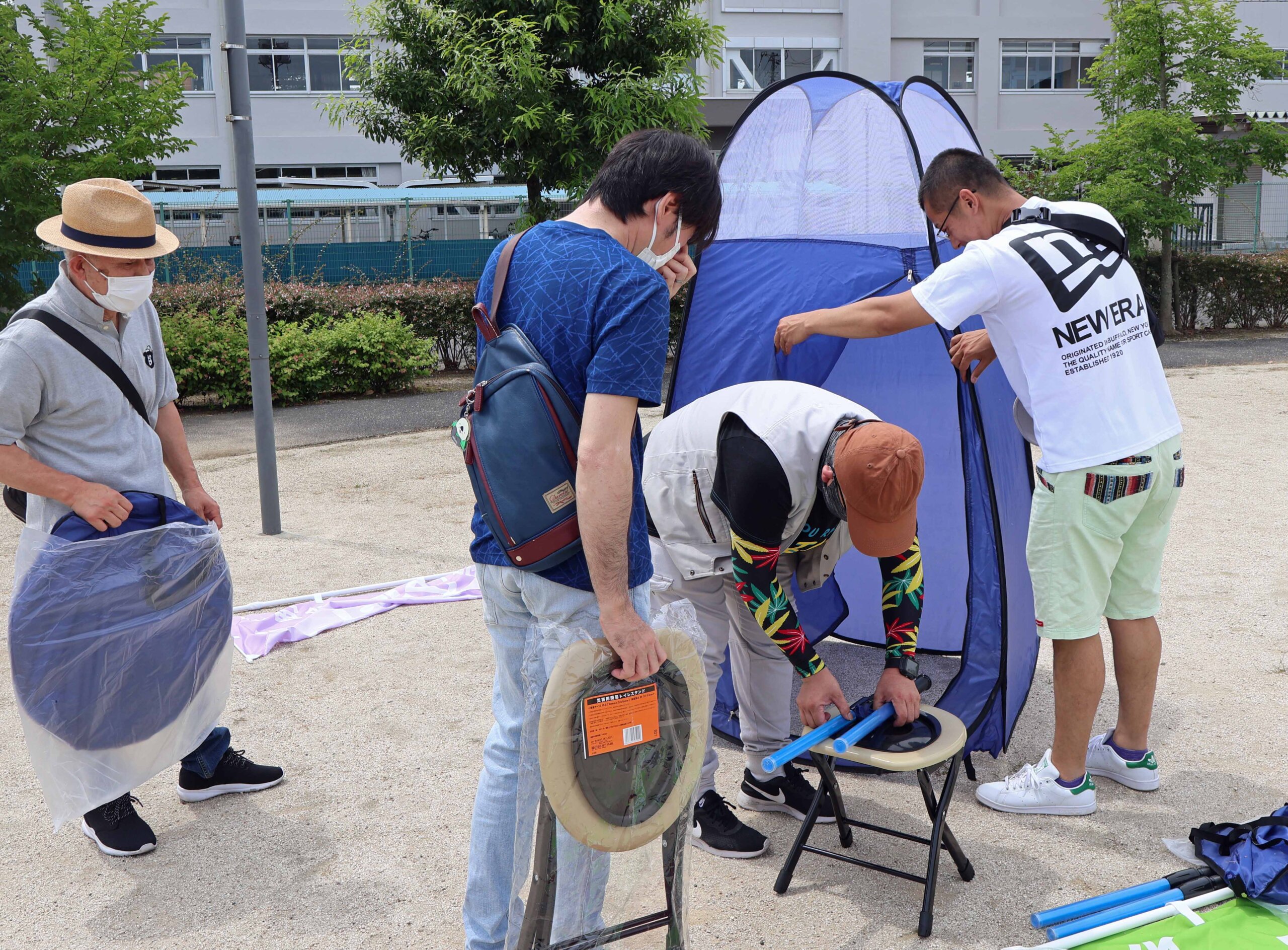 簡易トイレの設置の手順を確認し、組み立てを行う参加者ら