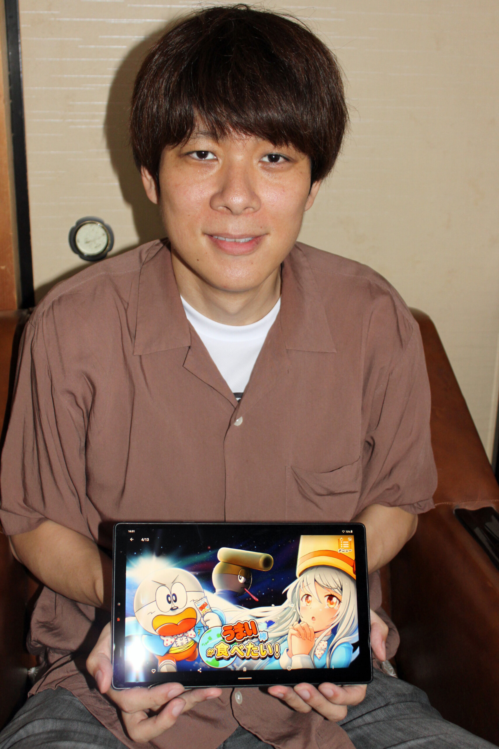 ゲーム画面を写したタブレットを手にする小川さん