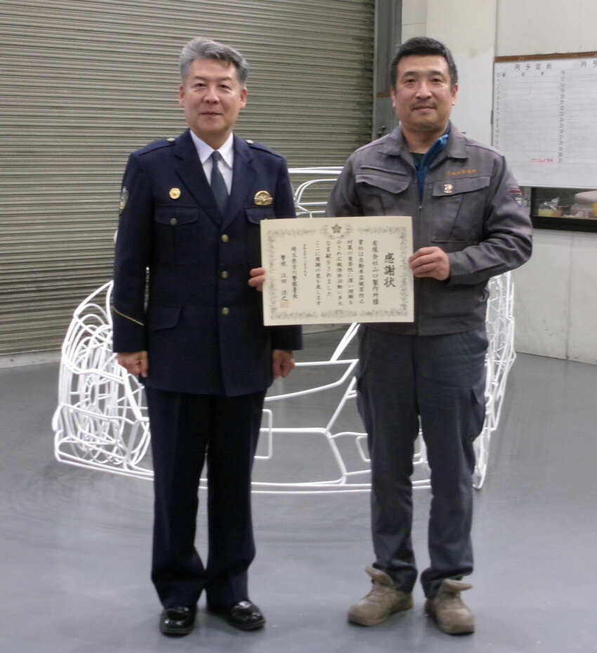 吉川署の江田署長（左）から感謝状を贈られた山口製作所の山口代表取締役
