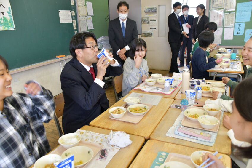 ストローを使わず牛乳を飲む方法を教わる福田市長と児童ら