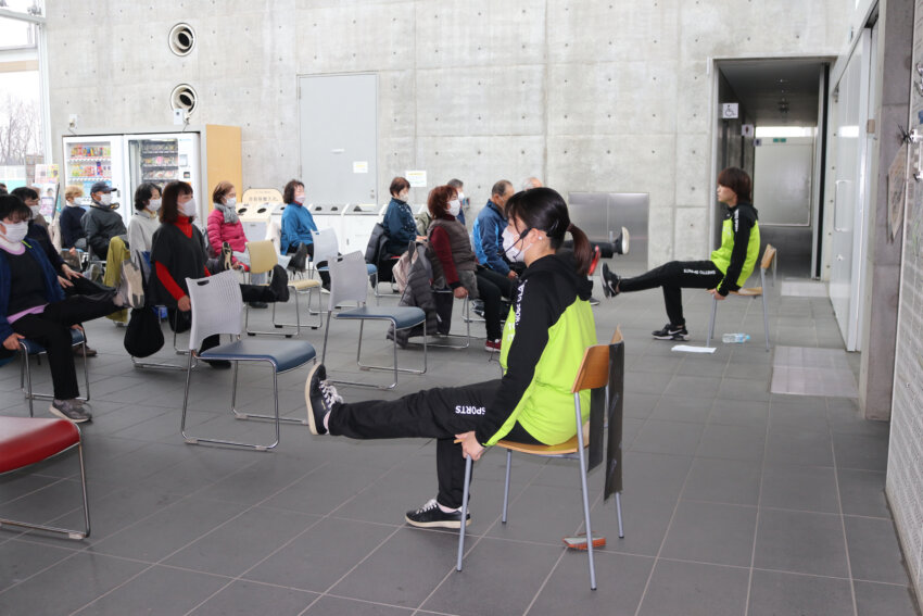 住民に膝の痛みを緩和する体操を指導する県立大の学生たち