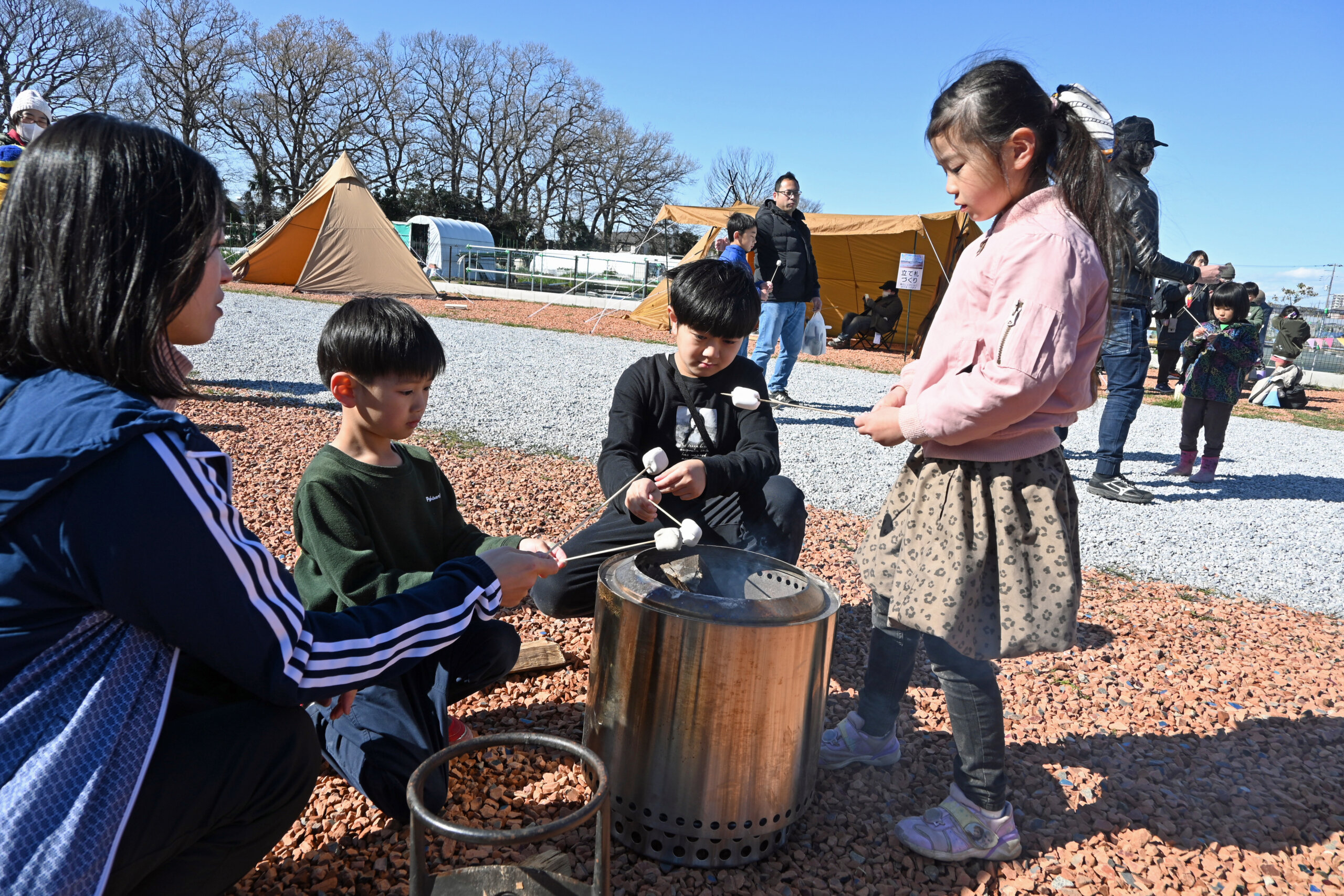 焚き火コーナーでマシュマロを焼く子どもたち