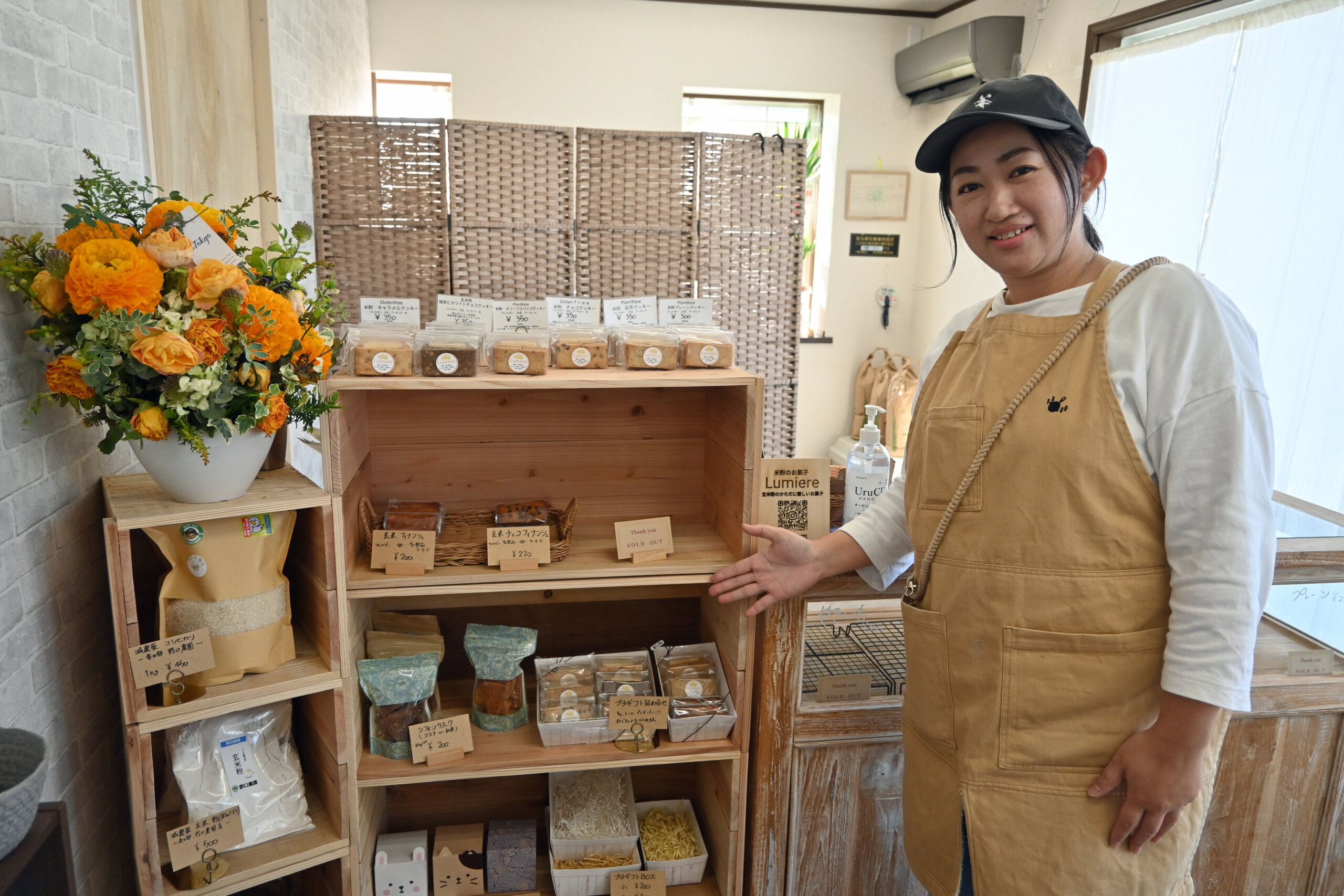 棚には、クッキーやカヌレが並ぶ。写真はオーナーの中野さん。