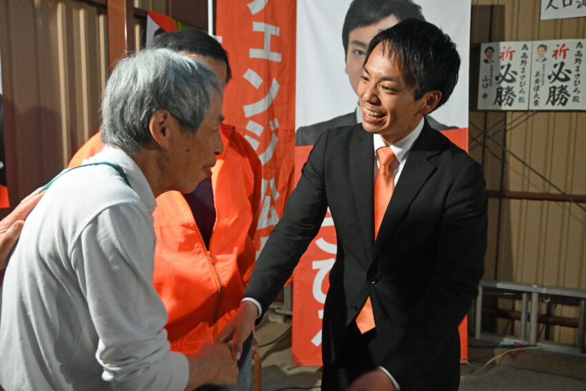 笑顔で支援者と握
手する高野氏（右）