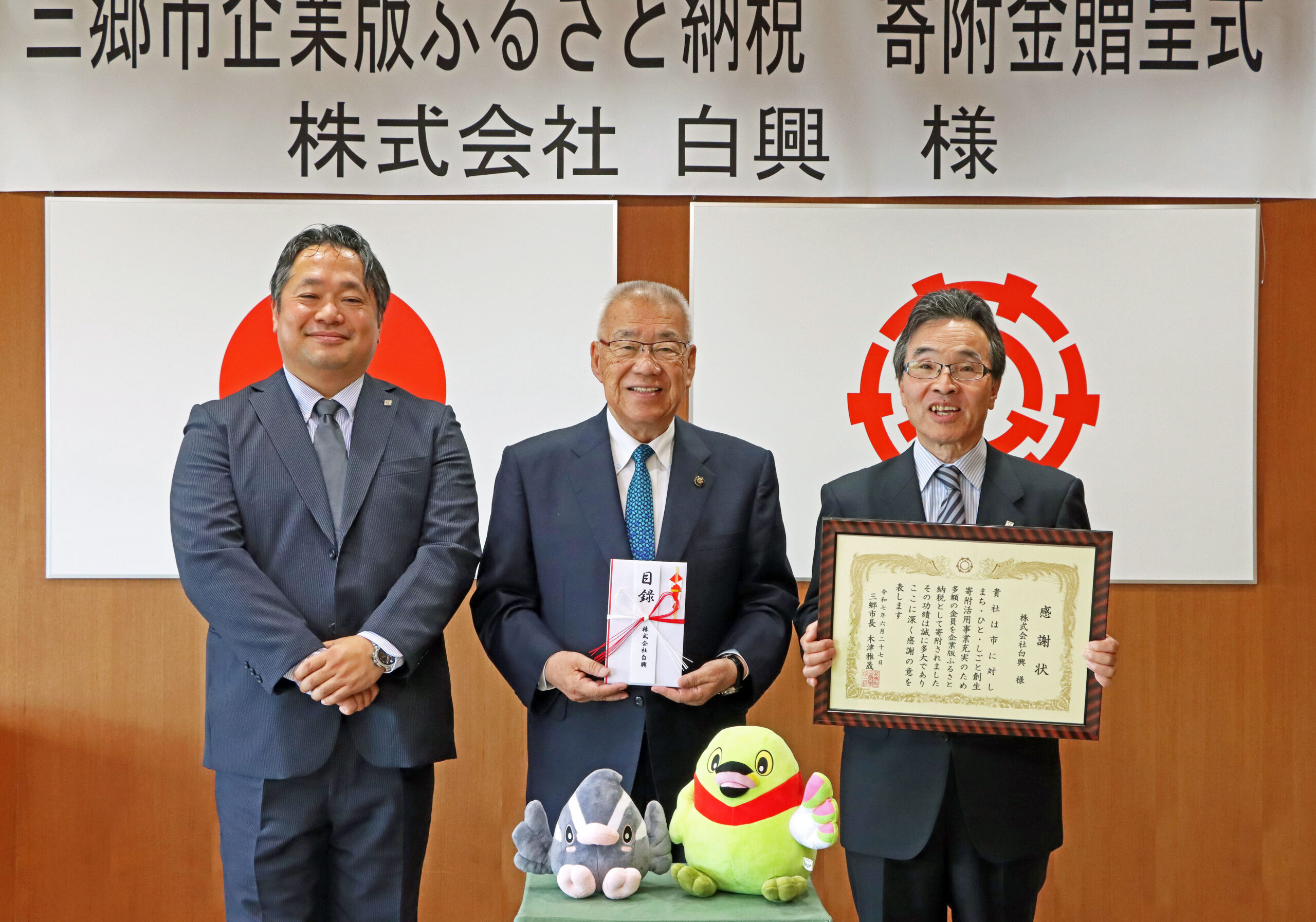 木津市長（中央）に企業版ふるさと納税を手渡した堀井社長（右）